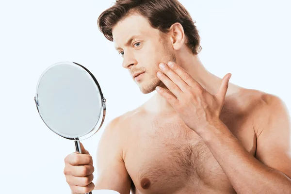 Uomo senza maglietta toccare la pelle, mentre tenendo specchio isolato su bianco — Foto stock