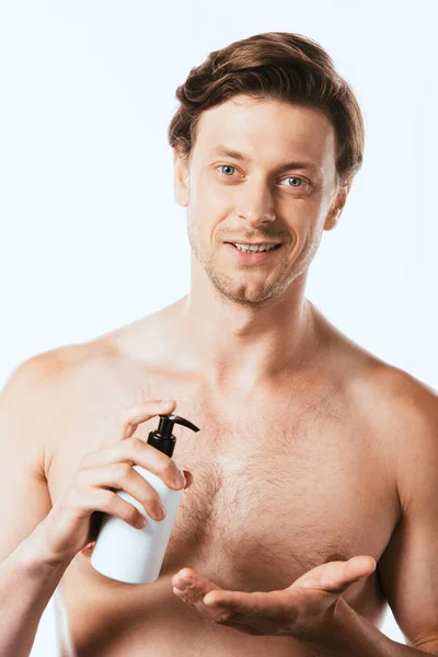 Giovane uomo muscolare in possesso di bottiglia di lozione isolata su bianco — Foto stock