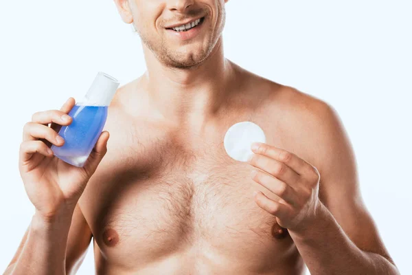 Cropped view of shirtless man holding bottle of toner and cotton pad isolated on white — Stock Photo