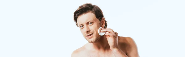 Colpo panoramico di uomo senza camicia che tiene pad di cotone vicino al viso isolato su bianco — Foto stock