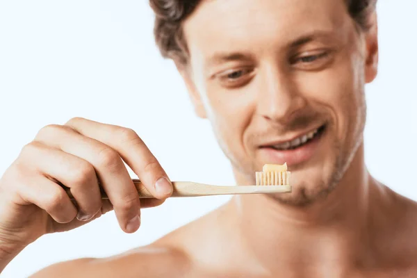 Selektiver Fokus des hemdslosen Mannes, der eine Zahnbürste mit Zahnpasta hält, die auf weiß isoliert ist — Stockfoto