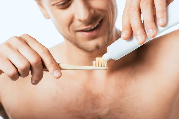 Vista cortada de homem sem camisa segurando escova de dentes e pasta de dentes isolada em branco — Fotografia de Stock