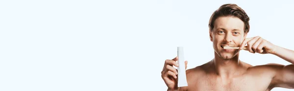 Horizontal crop of shirtless man brushing teeth and showing toothpaste isolated on white — Stock Photo