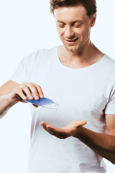 Man in white t-shirt pouring toner in hand isolated on white — Stock Photo