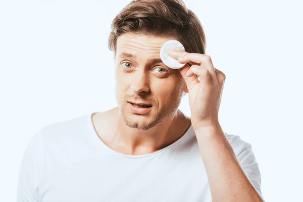 Young man holding cotton pad near forehead isolated on white — Stock Photo