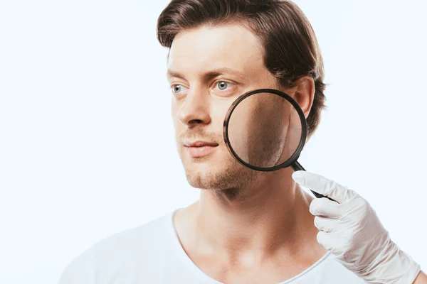 Man looking away near dermatologist holding loupe isolated on white — Stock Photo