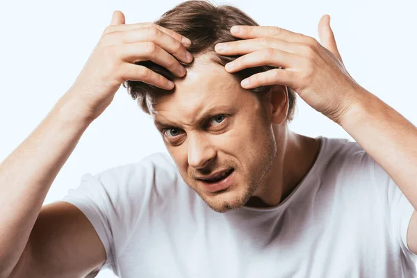 Uomo insoddisfatto toccare i capelli e guardando la fotocamera isolata su bianco — Foto stock