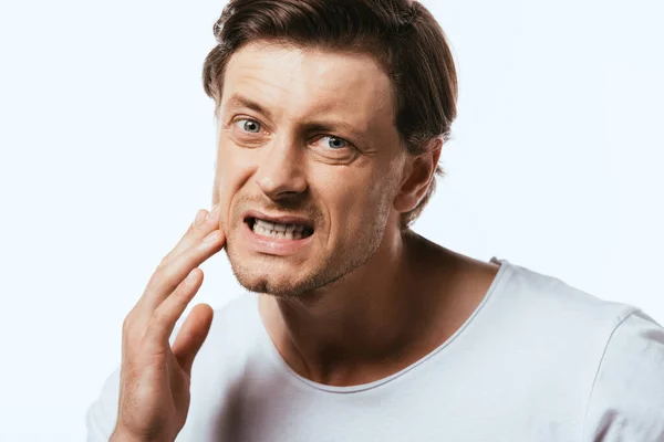 Dissatisfied man touching skin on cheek isolated on white — Stock Photo