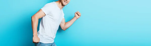 Panoramic crop of man in white t-shirt on blue background — Stock Photo