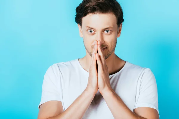 Man showing please gesture while looking at camera on blue background — Stock Photo