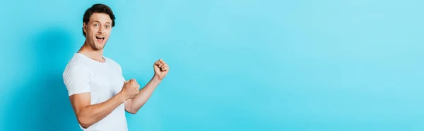 Horizontal concept of man in white t-shirt showing okay gesture on blue background — Stock Photo