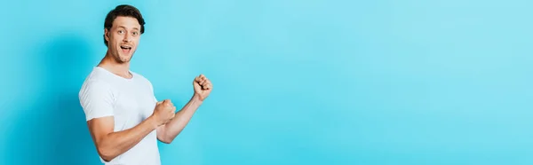 Horizontales Konzept des Mannes in weißem T-Shirt mit Okay-Geste auf blauem Hintergrund — Stockfoto