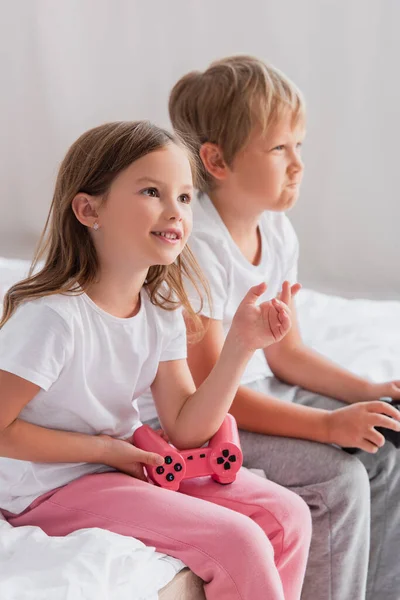 KYIV, UKRAINE - JULY 21, 2020: selective focus of girl holding joystick near concentrated brother playing video game — Stock Photo