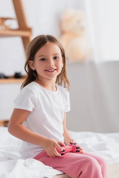 KYIV, UCRANIA - 21 de julio de 2020: chica con camiseta blanca mirando a la cámara mientras sostiene el joystick - foto de stock