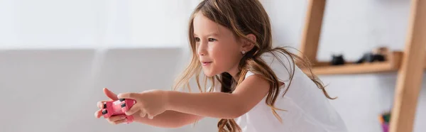 KYIV, UCRANIA - 21 de julio de 2020: imagen horizontal de una chica concentrada en camiseta blanca jugando videojuegos con joystick - foto de stock