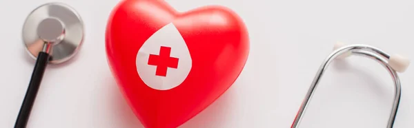 Vista dall'alto del cuore rosso e dello stetoscopio sul bianco, concetto di donazione di sangue — Stock Photo