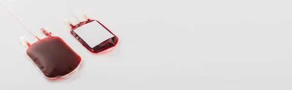 Blood donation packages with blank label on white background, panoramic shot — Stock Photo