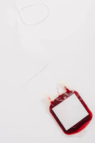 Vista superior del paquete de donación de sangre con etiqueta en blanco sobre fondo blanco - foto de stock