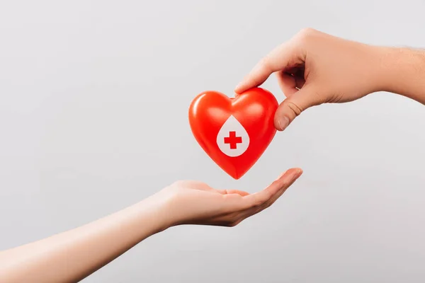 Обрізаний вид чоловіка і жінок з червоним серцем ізольовано на білому фоні, концепція донорства крові — стокове фото