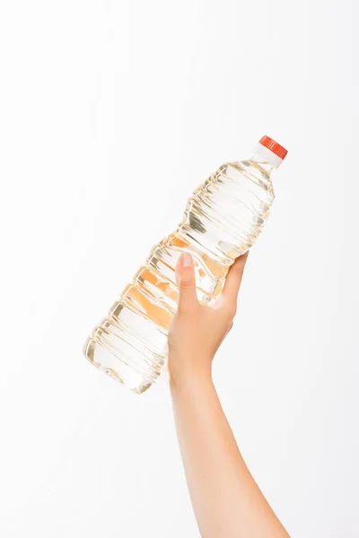 Vista cortada de mulher segurando garrafa de óleo isolado em branco, conceito de caridade — Fotografia de Stock