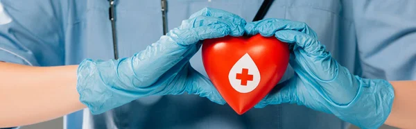 Cropped view of doctor with stereoscope holding red heart, blood donation concept — Stock Photo