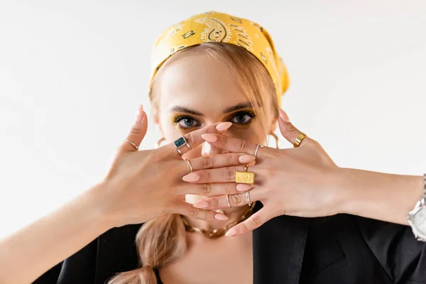 Femme à la mode en foulard jaune et accessoires dorés avec les mains devant le visage isolé sur blanc — Photo de stock