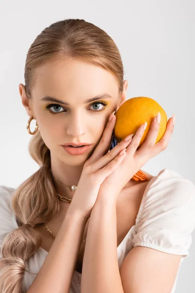 Mulher loira elegante posando com laranja isolada no branco — Fotografia de Stock