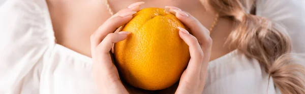 Vista cortada de mulher loira elegante segurando laranja, tiro panorâmico — Fotografia de Stock