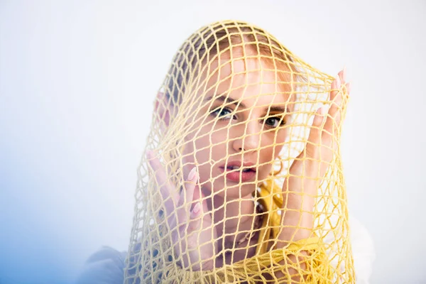 Woman posing in yellow string bag on white background — Stock Photo