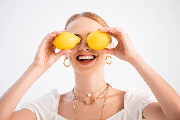 Funny elegant blonde woman posing with lemons on eyes isolated on white — Stock Photo