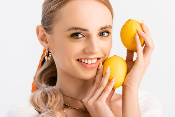 Donna bionda in posa con limoni gialli isolati su bianco — Foto stock