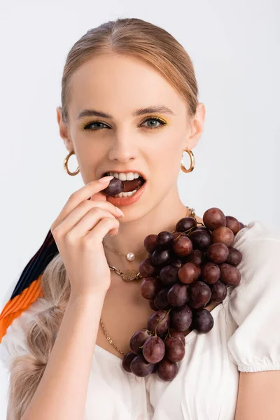 Donna bionda rustica mordere uva isolata su bianco — Foto stock
