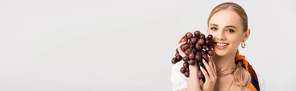 Mujer rubia rústica posando con uvas aisladas en blanco, plano panorámico - foto de stock