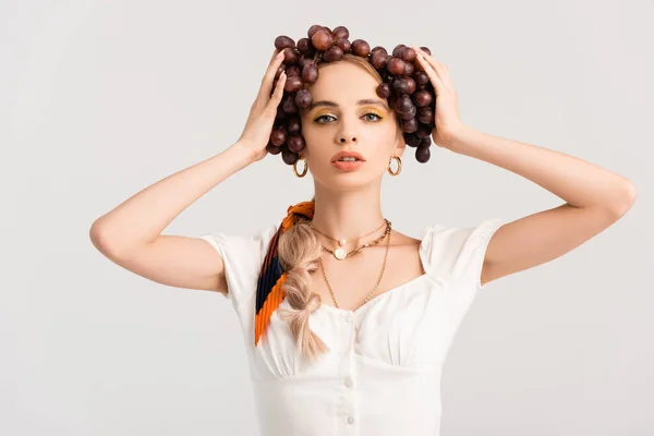 Mujer rubia rústica posando con uvas en la cabeza aislada en blanco - foto de stock