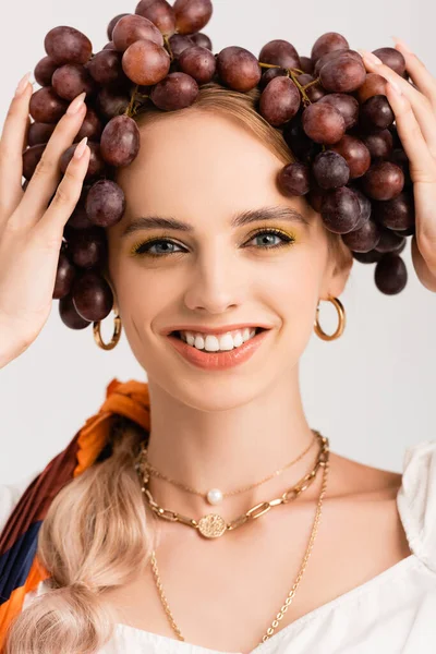 Portrait de femme blonde rustique posant avec des raisins sur la tête isolé sur blanc — Photo de stock