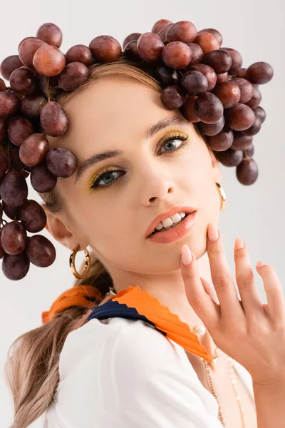 Portrait of rustic blonde woman posing with grapes on head isolated on white — Stock Photo