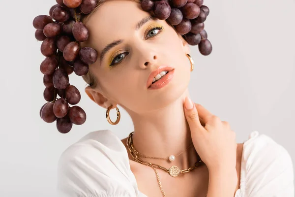Portrait of rustic blonde woman posing with grapes on head isolated on white — Stock Photo