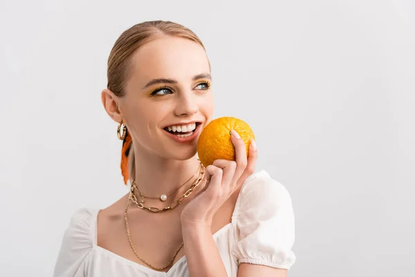 Блондинка позує з апельсином ізольована на білому — стокове фото