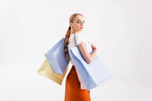 Vista lateral de mujer elegante con bolsas aisladas en blanco - foto de stock