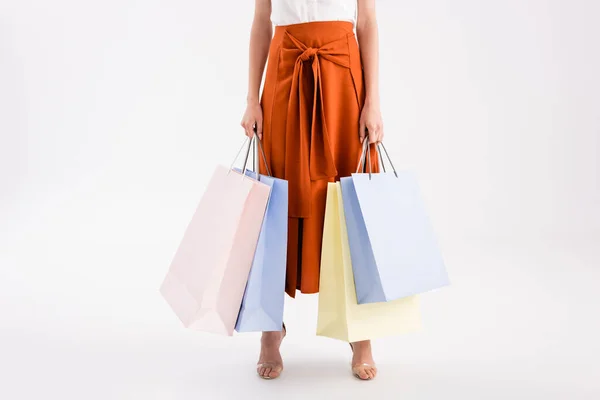 Vista recortada de mujer elegante con bolsas de compras en blanco - foto de stock