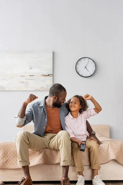 Збуджений афроамериканський батько і дочка показують жест переможця, дивлячись один на одного — Stock Photo