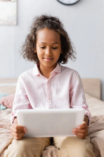 Afrikanerin im weißen Hemd mit digitalem Tablet im Schlafzimmer — Stockfoto