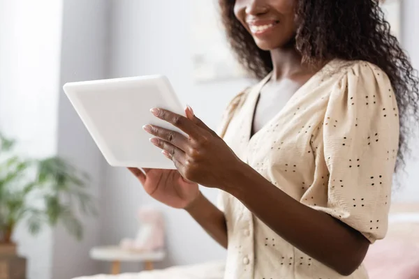 Vista cortada da mulher americana africana em blusa usando tablet digital em casa — Fotografia de Stock