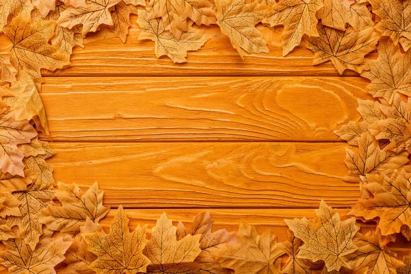 Верхний вид осенней листвы, расположенной в рамке на деревянном фоне — стоковое фото