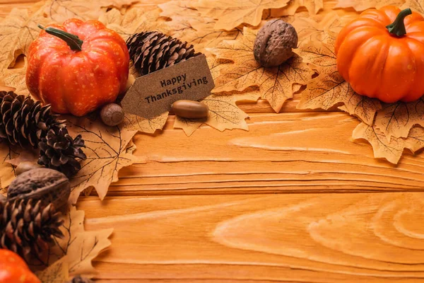 Abóboras, decoração outonal e cartão de ação de graças feliz no fundo de madeira — Fotografia de Stock