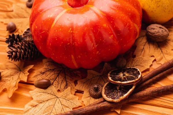 Calabaza con decoración otoñal sobre fondo de madera - foto de stock