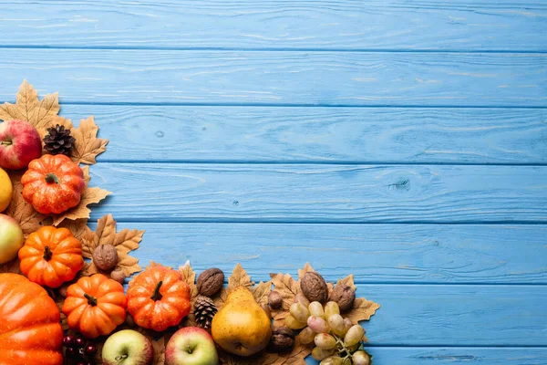 Верхний вид осеннего урожая и листвы на голубом деревянном фоне — стоковое фото