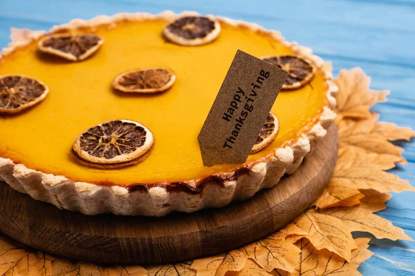 Close up view of decorated pumpkin pie with happy thanksgiving card — Stock Photo