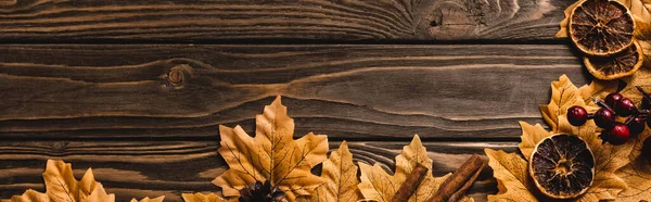 Top view of autumnal decoration and foliage on brown wooden background, panoramic shot — Stock Photo