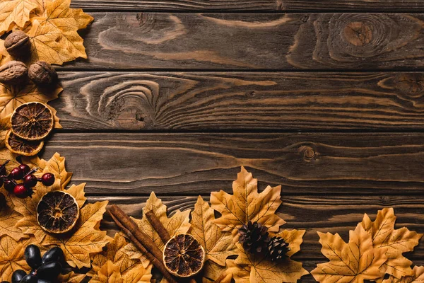 Top view of autumnal decoration and foliage on brown wooden background — Stock Photo